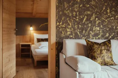 a living room with a couch and a bedroom at Refugium LaFlu Apartments in Corvara in Badia
