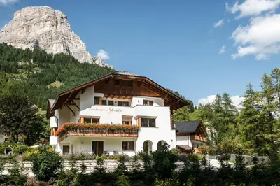 a white house with a mountain in the background at Residence Floralp in Colfosco