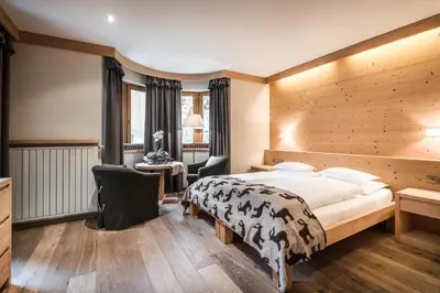 a hotel room with a bed and a desk at Residence Floralp in Colfosco