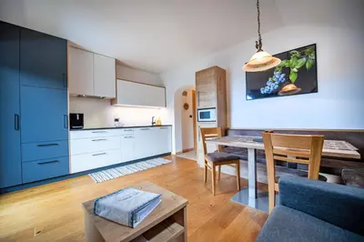 a kitchen and living room with a table and a couch at Ausservogelweiderhof in Ponte Gardena