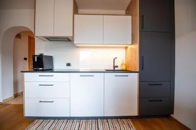 a kitchen with white cabinets and a sink at Ausservogelweiderhof in Ponte Gardena
