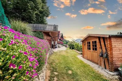 a garden with pink flowers next to a building at Ausservogelweiderhof in Ponte Gardena
