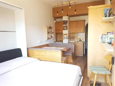 a small room with a bed and a kitchen at Casa Mowgli - Residence Sussy in Falcade