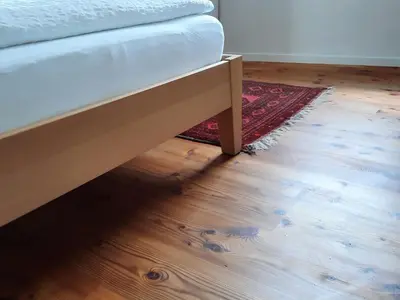 a bed sitting on top of a wooden floor at Apartment Le rose di Marianne - sud in Varna
