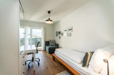 a bedroom with a bed and a desk and a window at Apartment Le rose di Marianne - sud in Varna