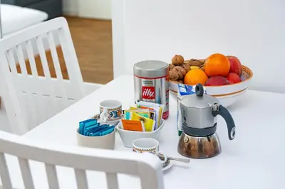 a white table with a bowl of fruit and a coffee maker at Apartment Le rose di Marianne - ovest in Varna