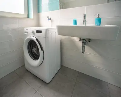 a bathroom with a washing machine and a sink at Apartment Le rose di Marianne - ovest in Varna