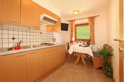 a kitchen with a sink and a table and a window at Schmözlhof in Tesido