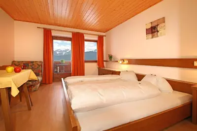 a bedroom with a bed and a table and a window at Schmözlhof in Tesido