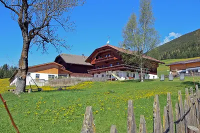 a house in a field next to a fence at Schmözlhof in Tesido
