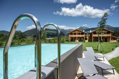 a swimming pool with chairs and a house at Kessler's Mountain Lodge in Naz-Sciaves