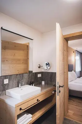 a bathroom with a sink and a bed at Kessler's Mountain Lodge in Naz-Sciaves