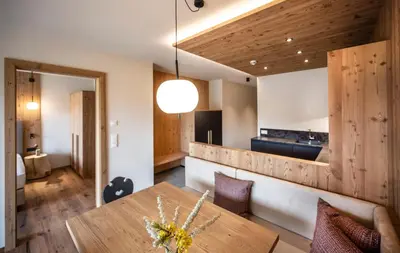 a dining room with a table and a kitchen at Kessler's Mountain Lodge in Naz-Sciaves