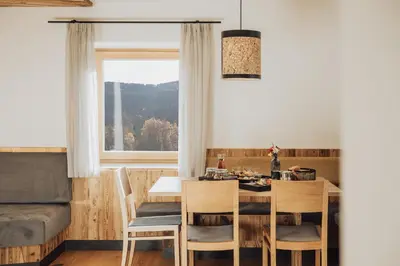 a dining room with a table and chairs and a window at Untermathonhof Vöran - Ferienwohnungen - Urlaub am Bauernhof in Südtirol mit hofeigenem Frühstück in Verano