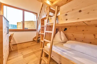 a bedroom with bunk beds in a wooden house at Untermathonhof Vöran - Ferienwohnungen - Urlaub am Bauernhof in Südtirol mit hofeigenem Frühstück in Verano