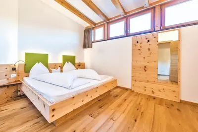 a bedroom with a bed in a room with wooden floors at Untermathonhof Vöran - Ferienwohnungen - Urlaub am Bauernhof in Südtirol mit hofeigenem Frühstück in Verano