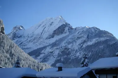 a mountain covered in snow in front of a house at Des Alpes 2 in Canazei