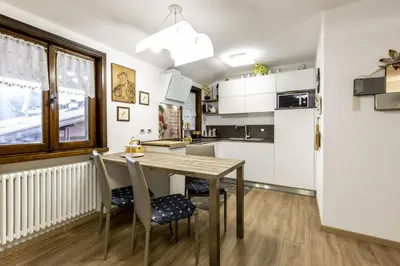 a kitchen with a wooden table and chairs at Des Alpes 2 in Canazei