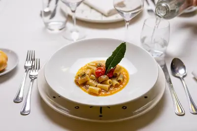 a white plate of food on a table with silverware at Phi Hotel Bellamonte in Predazzo