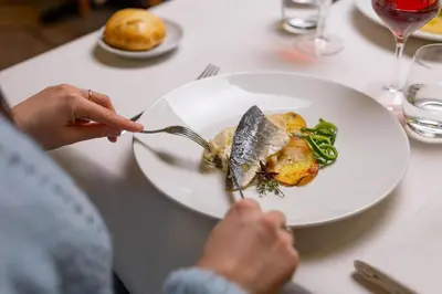 a person eating a plate of food on a table at Phi Hotel Bellamonte in Predazzo