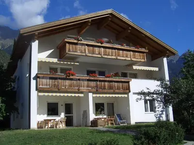 a large white house with a balcony at Ferienwohnung im Haus Texel III in Parcines