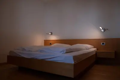 a bed in a room with two lights on the wall at Ferienwohnung im Haus Texel III in Parcines