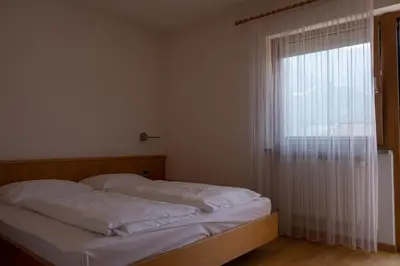a bed in a room with a large window at Ferienwohnung im Haus Texel III in Parcines