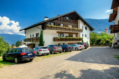 a building with cars parked in front of it at Garni-Hotel Farmerhof in Parcines