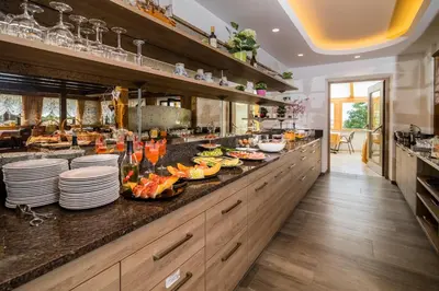 a large kitchen with dishes on a counter at Garni-Hotel Farmerhof in Parcines