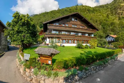 a house with a green lawn in front of it at Garni-Hotel Farmerhof in Parcines