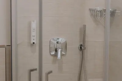 a shower with a glass door with a toothbrush at Garni-Hotel Farmerhof in Parcines