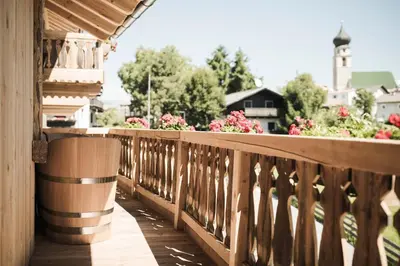 a wooden balcony with flowers on a house at Huberhof in Fiè