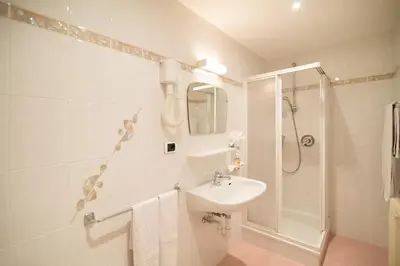 a white bathroom with a sink and a shower at Haus St. Valentin in Appiano sulla Strada del Vino