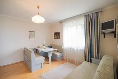 a small living room with a table and a window at Haus St. Valentin in Appiano sulla Strada del Vino