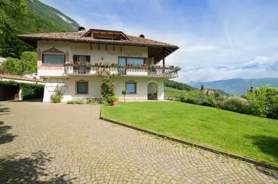 a house on a hill with a green yard at Haus St. Valentin in Appiano sulla Strada del Vino