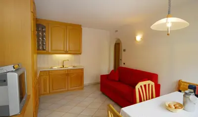 a kitchen with a red couch and a table at Urthalerhof in Castelrotto