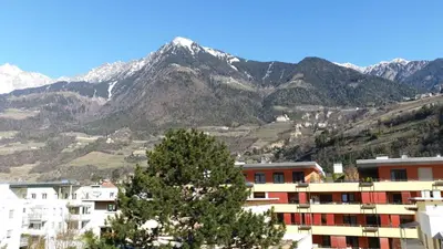 a city with a mountain in the background at Giuchry Apartment in Merano
