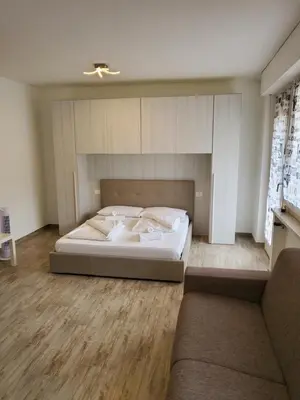 a bedroom with a bed and a couch at Giuchry Apartment in Merano