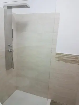 a shower with a glass door in a bathroom at Giuchry Apartment in Merano