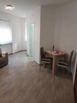 a living room with a table and chairs at Giuchry Apartment in Merano