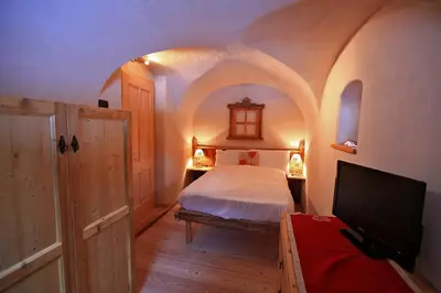 a bedroom with a bed and a tv in it at Maso Toneto in Castello di Fiemme