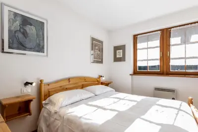 a bedroom with a bed and a window at El Tobià in Campitello