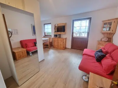 a living room with a red couch and a mirror at El Tobià in Campitello