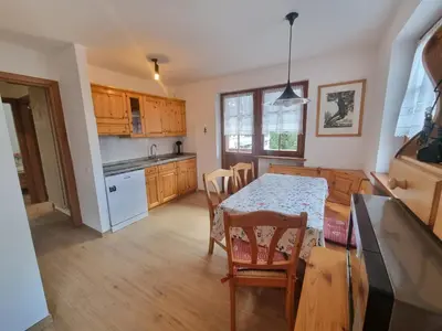 a kitchen and dining room with a table and chairs at El Tobià in Campitello