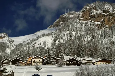 a snow covered mountain with a group of buildings at El Tobià in Campitello