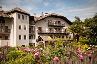 a building with flowers in front of it at Hotel Weingut Stroblhof in Appiano sulla Strada del Vino