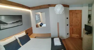 a bedroom with a bed and a tv in a room at Casa Zone in Tesero