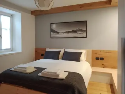 a bedroom with a bed with two towels on it at Casa Zone in Tesero