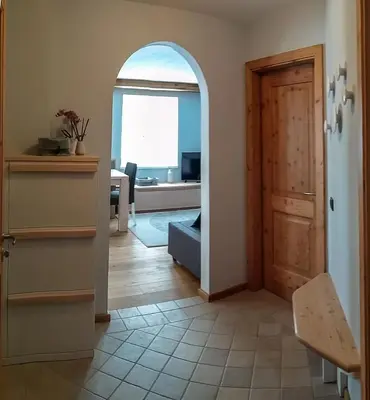 a hallway with a door and a living room at Casa Zone in Tesero
