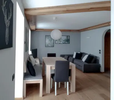 a living room with a table and a couch at Casa Zone in Tesero